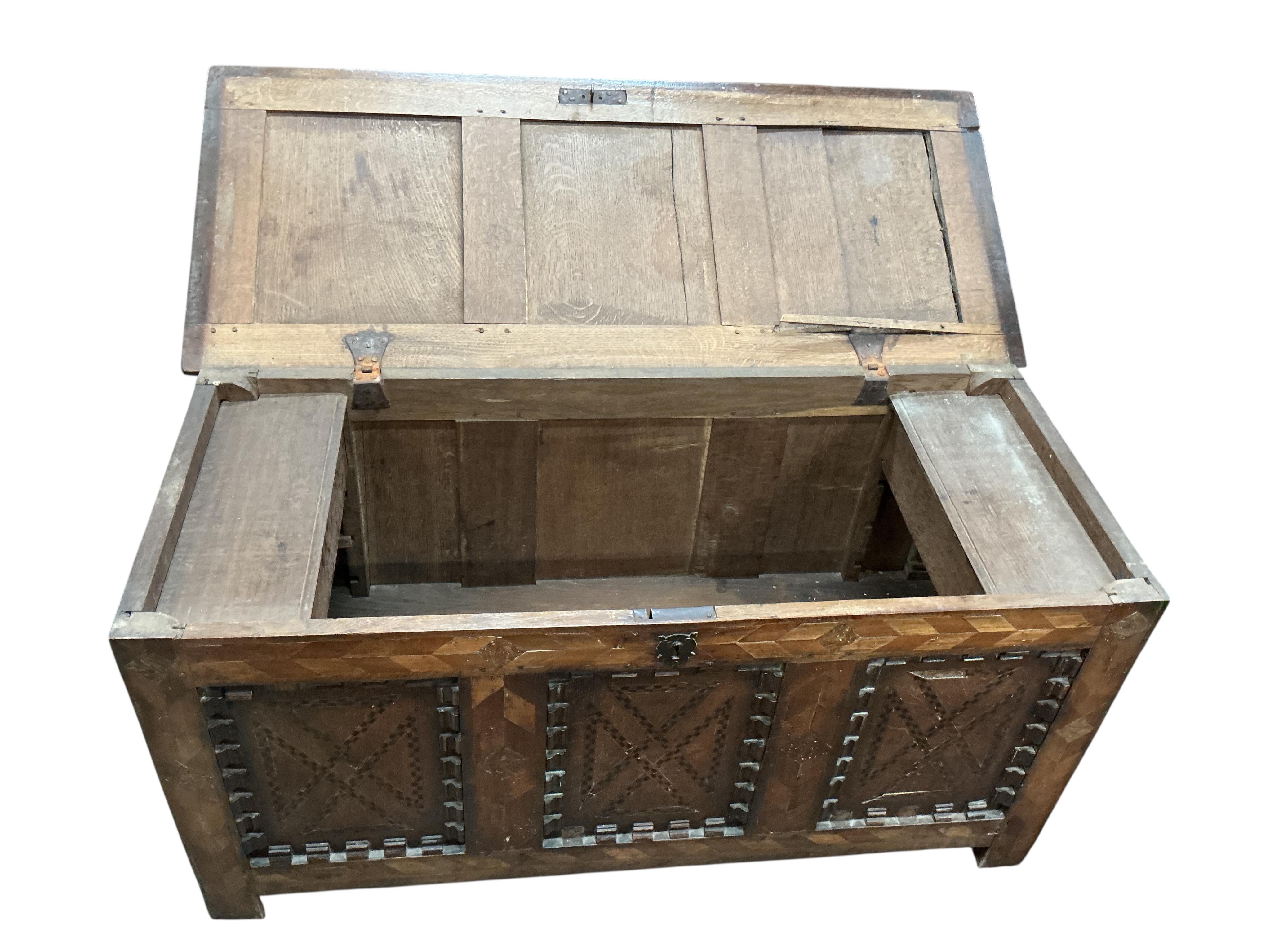 An early 18th century parquetry inlaid panelled oak coffer, width 131cm, depth 54cm, height 64cm